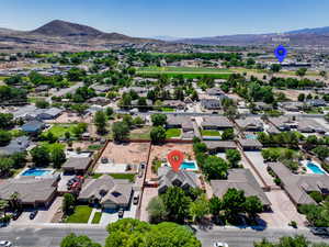 Aerial view of residential area with a mountain backdrop and a pool