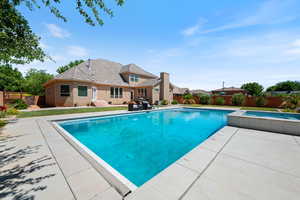 View of swimming pool featuring an in-ground hot tub, a fenced backyard, a patio area, and entry steps
