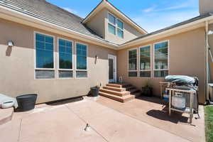 Rear view of house with stucco siding and a patio area