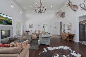 Living area featuring a high ceiling, a multi sided fireplace, healthy amount of natural light, and wood-type flooring