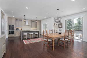 Dining room featuring dark wood finished floors, a chandelier, and recessed lighting