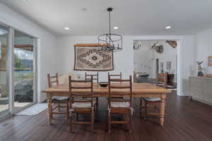 Dining space with a chandelier, dark wood finished floors, and recessed lighting