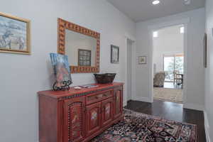 Hall with dark wood-style flooring and recessed lighting