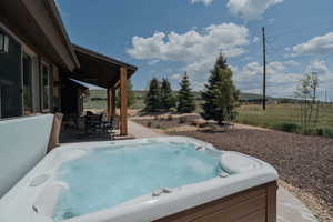 View of pool featuring a patio area, a hot tub, and outdoor dining area