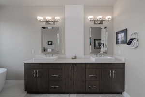 Full bath with double vanity and tile patterned flooring