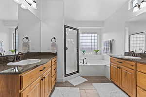 Bathroom with two vanities, a shower stall, a bath, and tile patterned flooring