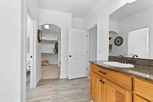 Full bath featuring vanity and a walk in closet