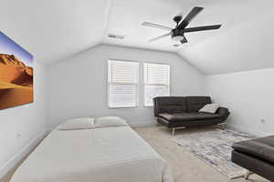 Bedroom featuring lofted ceiling, ceiling fan, and light colored carpet