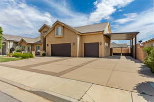 View of front of house featuring concrete driveway, stucco siding, a tile roof, a garage, and a carport