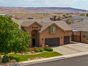View of front of house featuring stucco siding, a mountain view, concrete driveway, a tiled roof, and a residential view