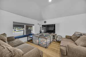 Living room with lofted ceiling and wood finished floors