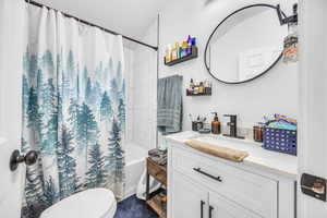 Bathroom featuring vanity and shower / bath combination with curtain