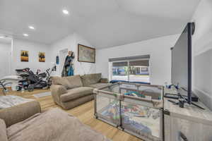 Living area with wood finished floors, recessed lighting, and vaulted ceiling