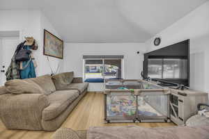 Living room featuring wood finished floors and vaulted ceiling
