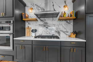 Kitchen featuring open shelves, extractor fan, stainless steel appliances, and backsplash