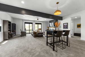 Dining space with light carpet, recessed lighting, a ceiling fan, and beamed ceiling