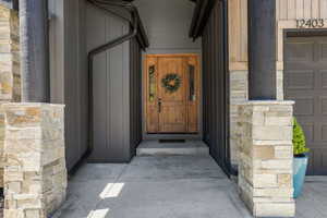 Entrance to property featuring stone siding