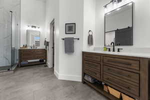 Full bath with a marble finish shower and two vanities