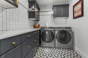 Laundry area featuring cabinet space, washing machine and clothes dryer, and tile patterned floors