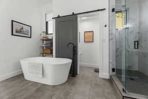 Bathroom featuring a marble finish shower and a freestanding bath