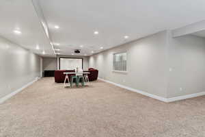 Cinema with light colored carpet and recessed lighting