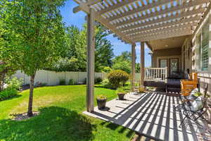 Fenced backyard featuring a pergola
