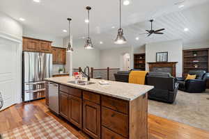 Kitchen with appliances with stainless steel finishes, arched walkways, a ceiling fan, wood finished floors, and recessed lighting