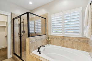 Bathroom featuring a bath and a stall shower