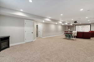 Living area with light colored carpet and recessed lighting