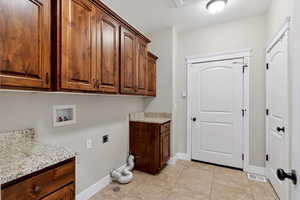 Laundry room featuring cabinet space, washer hookup, hookup for an electric dryer, and light tile patterned floors