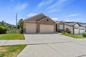 View of front facade featuring board and batten siding, an attached garage, brick siding, and concrete driveway