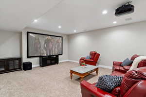 Carpeted home theater room with recessed lighting and baseboards