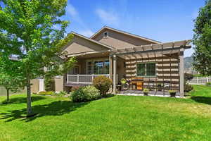 Back of house with stucco siding, a pergola, and a patio