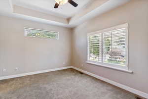 Carpeted spare room with healthy amount of natural light and a ceiling fan