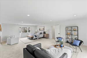 Bedroom featuring light carpet, recessed lighting, and a fireplace