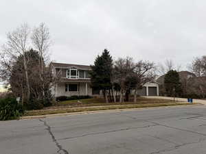 View of front facade featuring a garage, concrete driveway, and brick siding