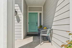 Doorway to property featuring covered porch