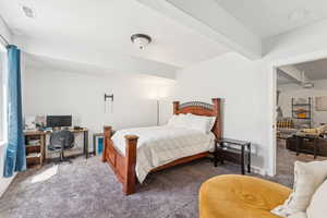 Carpeted bedroom featuring an office area and baseboards