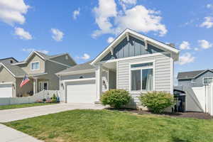 View of front of home with driveway, an attached garage, and board and batten siding