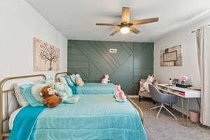 Carpeted bedroom featuring a textured ceiling and ceiling fan