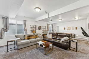 Living area with carpet floors, a textured ceiling, and healthy amount of natural light