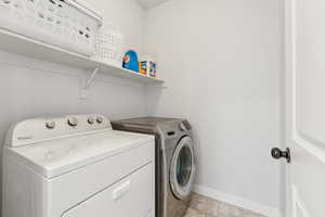 Laundry room featuring washer and dryer and baseboards