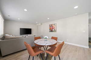Dining area with light wood-type flooring and recessed lighting