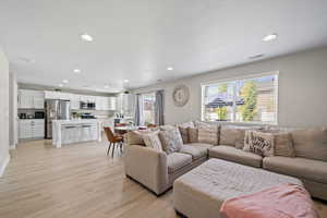 Living area with light wood-style flooring and recessed lighting