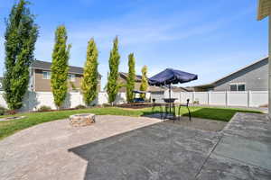 Fenced backyard featuring an outdoor fire pit, a patio, a residential view, and outdoor dining area