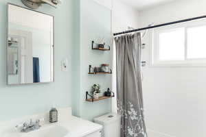Bathroom with vanity and shower / tub combo with curtain