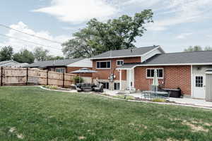 Rear view of property featuring an outdoor hangout area, a patio, a shingled roof, and brick siding