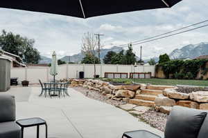 Fenced backyard with a patio area, a mountain view, and outdoor dining area