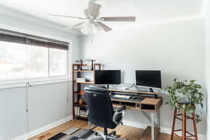 Office space with a ceiling fan, ornamental molding, and wood floors
