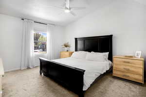 Bedroom featuring carpet flooring, vaulted ceiling, and a ceiling fan